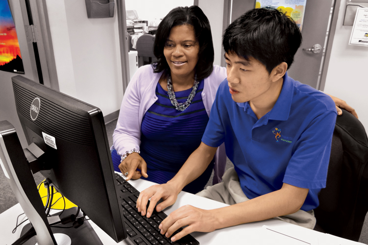 Karla Nabors supervises Steven Seo, who makes computer-generated certificates for students. Seo, who took classes in the College’s Challenge Program, now works one day a week at Montgomery College and another day for the Montgomery County Sheriff’s Office as part of SEEC Project SEARCH Montgomery.