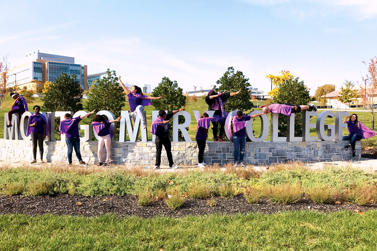 Montgomery College students show their school spirit during Spirit Week as they pose for a photo in front of the Montgomery College sign at the Germantown Campus.