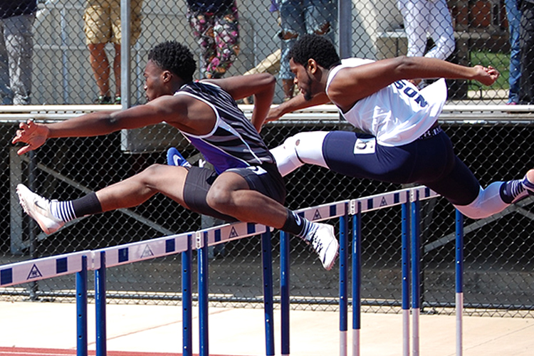 Bright Ofosu, left, competes in the 400m hurdles at the Gallaudet University Invitational for the Raptors.