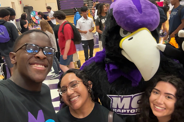 Raptor Reps taking a selfie with the MC Raptor mascot in a gym