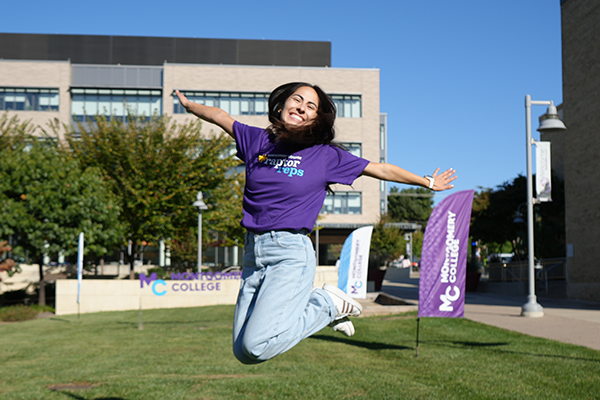 Raptor Rep Paola jumping in the air posing for a photo