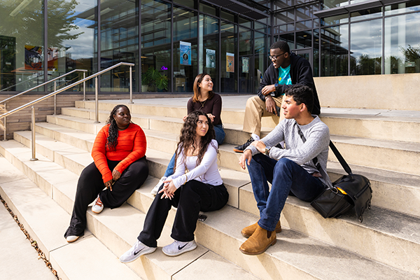 Raptor Rep students talking while sitting on steps on campus