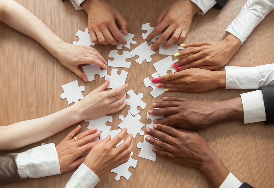 a closeup of hands piecing together a puzzle