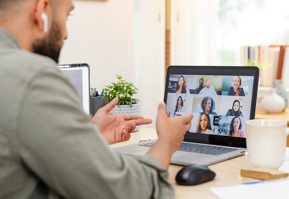 Individual teaching several students remotely on a laptop computer