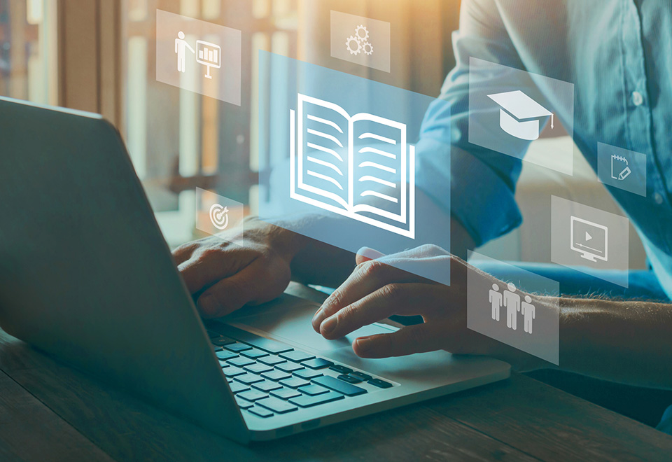 close up of an individuals hands typing on a laptop with overlayed educational icons